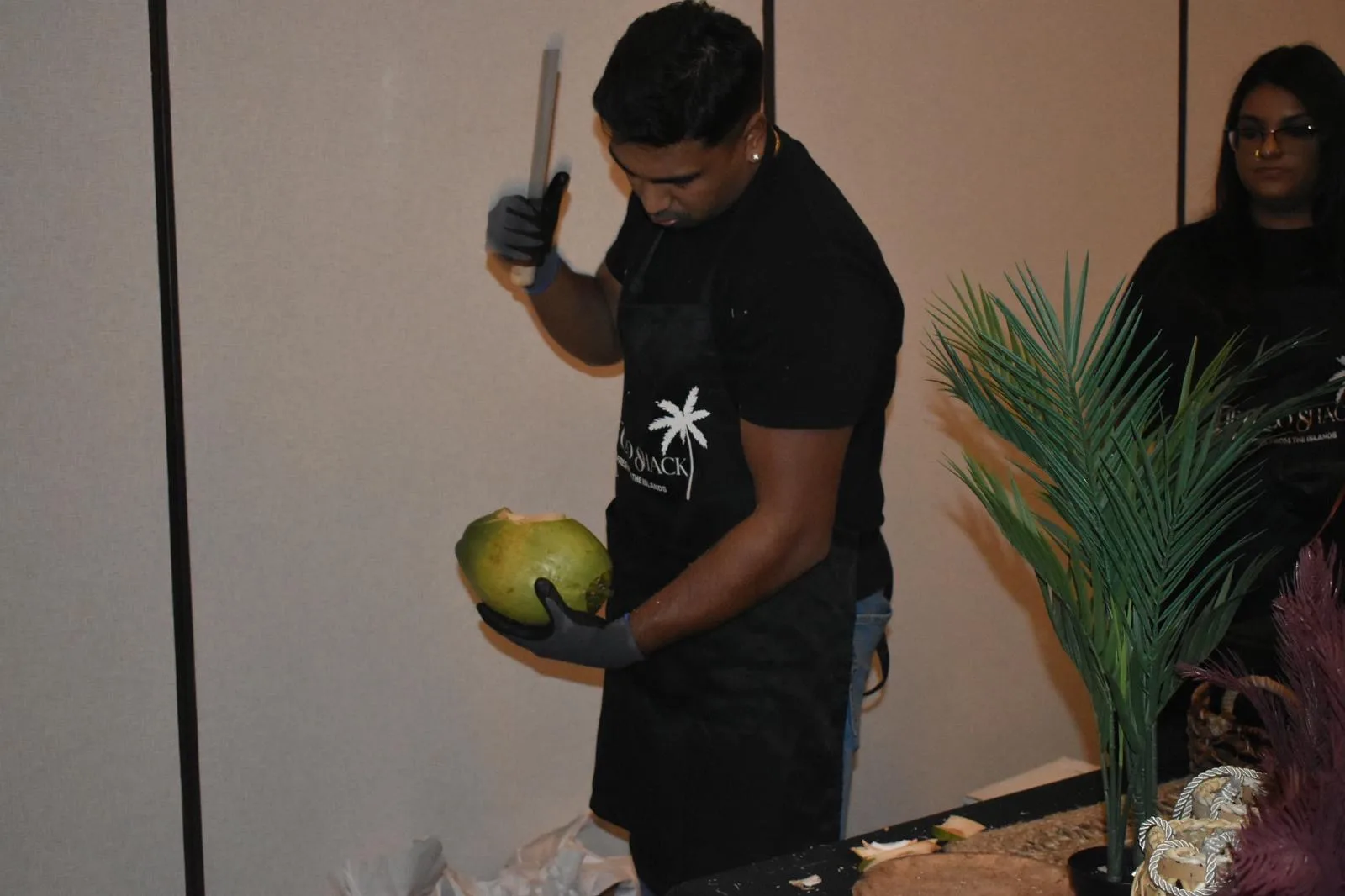 Andrew cutting a fresh coconut on site at an indoor event