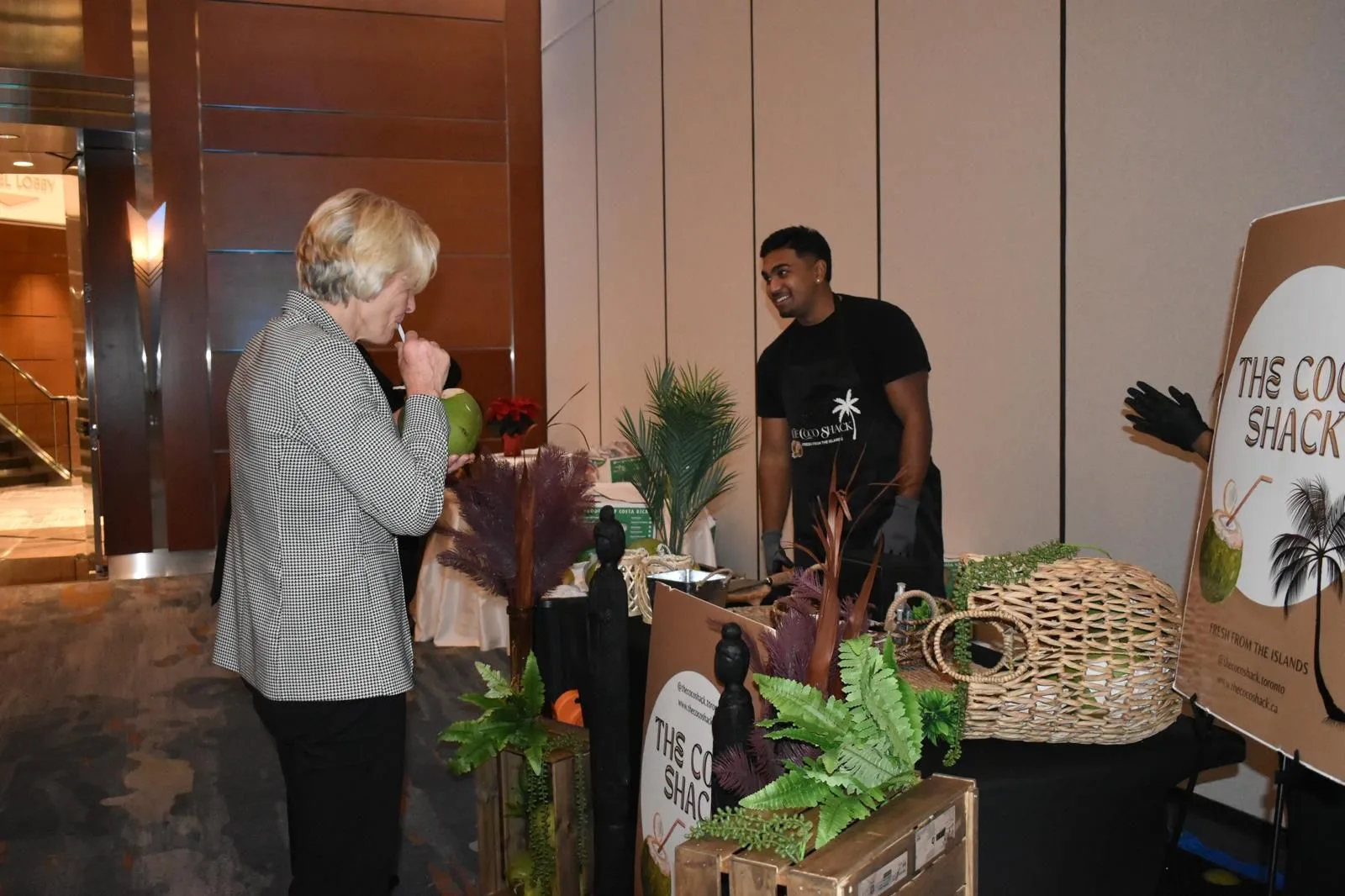 Andrew serving a coconut to a guest at an indoor gala